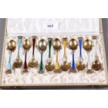 A set of twelve Danish white metal, gilt and enamelled coffee spoons with crown finials, stamped