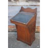 A late 19th century walnut Davenport type desk, with raised back over writing slope, pull-out pen