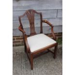 A late Georgian Sheraton design mahogany elbow chair with drop-in seat, on square taper supports