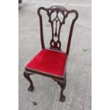 A mahogany dining chair of Chippendale design with carved pierced splat and drop-in seat, on