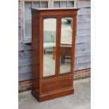 An Edwardian mahogany and banded wardrobe, fitted two arch top mirrored doors with bevelled plates