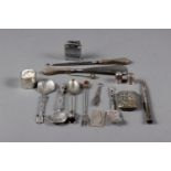 A group of silver and white metal items, including spoons, thimbles, manicure implements, a Polo