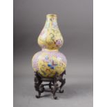 A Chinese double gourd vase with flower, fruit and geometric decoration on a yellow ground, 7 1/2"