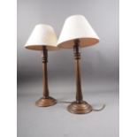 A pair of turned oak table lamps, on circular bases, 16 1/4" high