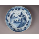 A Delft blue and white dish with landscape decoration, 10 1/2" dia (rim chips and frits)