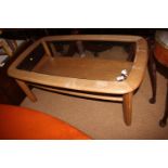 A 1970s light oak shape top two-tier coffee table with inset glass top, on shaped supports, 42" wide