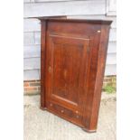 A late Georgian quarter cut oak and mahogany banded corner hanging cupboard enclosed glazed panel