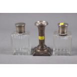 A pair of cut glass and silver topped scent bottles and stoppers, 4 1/4" high, and a filled silver