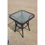 A square glass top garden table, on splay supports, 20" square x 24" high, and a smaller circular
