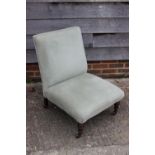 A late 19th century low seat nursing chair, upholstered in a sage green velour, on turned and