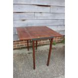 An early 20th century mahogany and brass mounted folding table with opening top, on square supports,