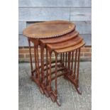 A nest of three figured walnut and banded oval occasional tables, on splay supports, 24" wide x