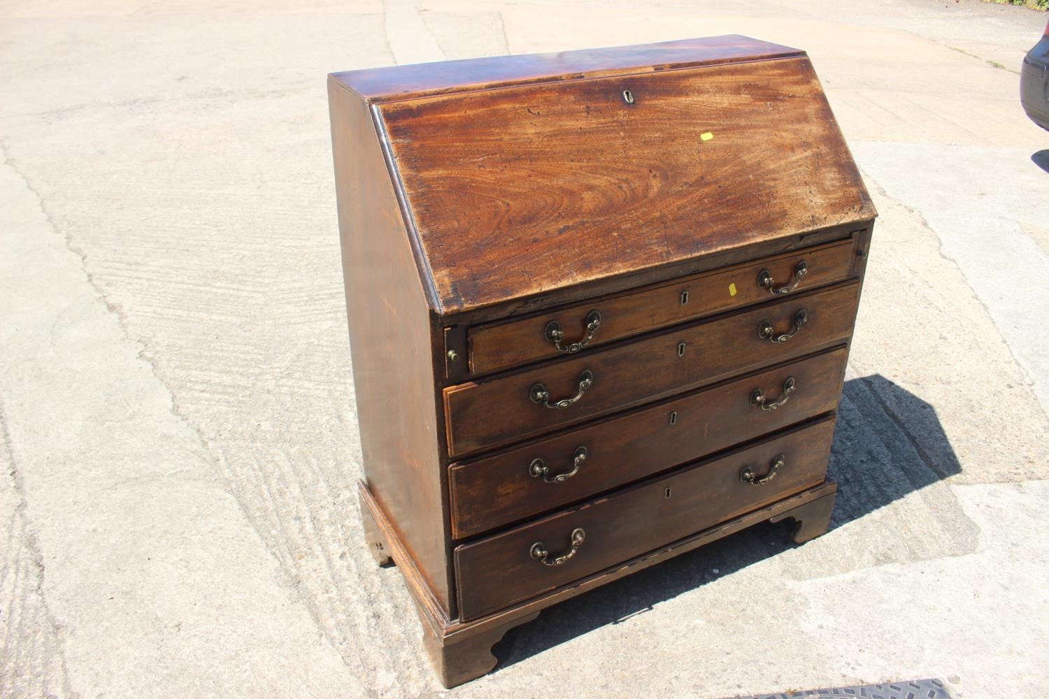 A Georgian mahogany bureau with fitted interior over four long graduated drawers, on bracket