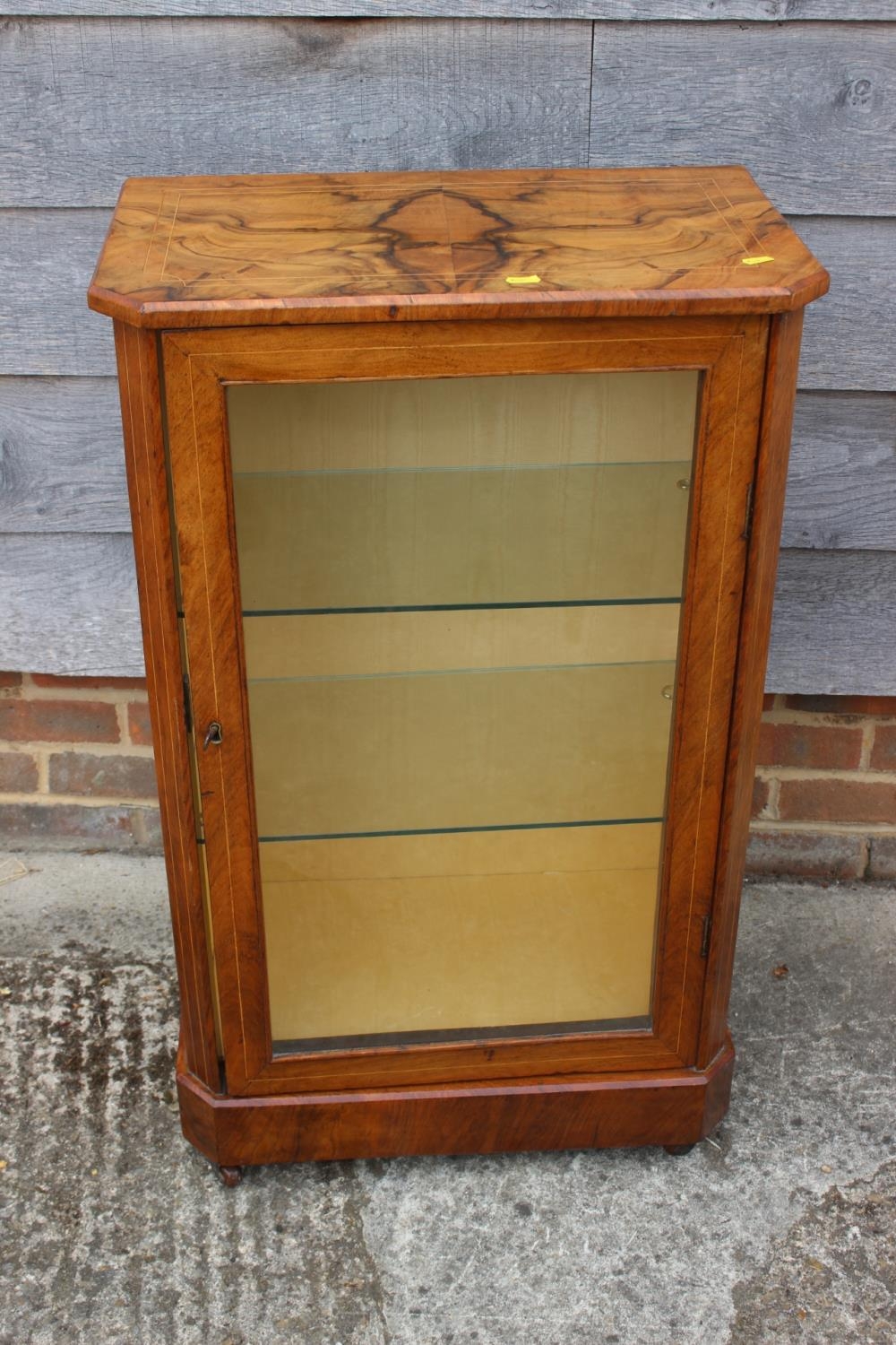 A 19th century walnut an line inlaid side cabinet with two glazed shelves enclosed glazed door, on