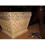 A cast stone planter with scroll design, 16" square
