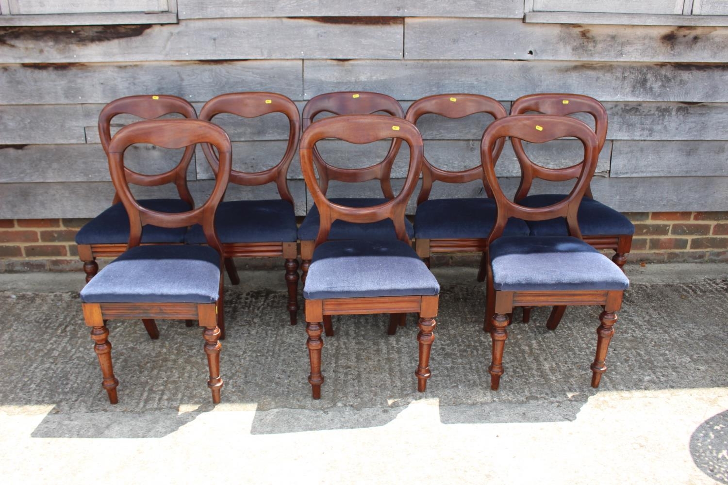 A set of eight 19th century mahogany balloon back standard dining chairs with padded seats,