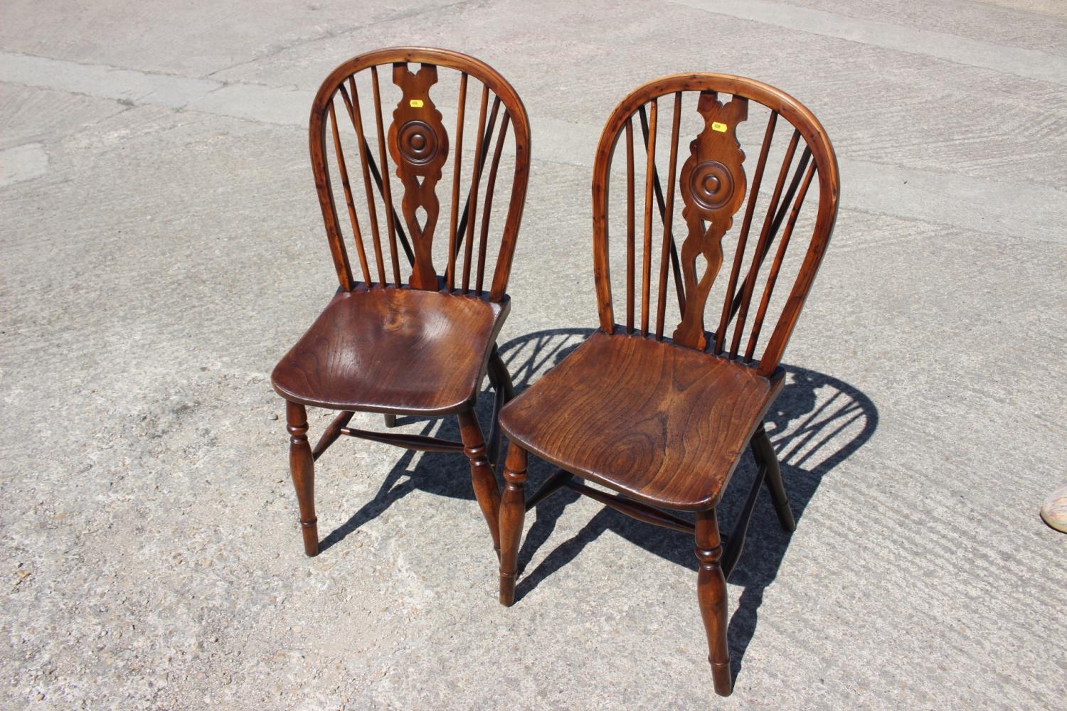 A pair of Windsor yew target splat back dining chairs with elm panel seats, on turned and