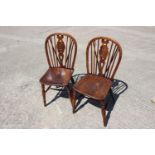 A pair of Windsor yew target splat back dining chairs with elm panel seats, on turned and
