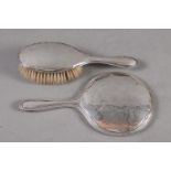 A silver backed dressing table mirror and a similar brush