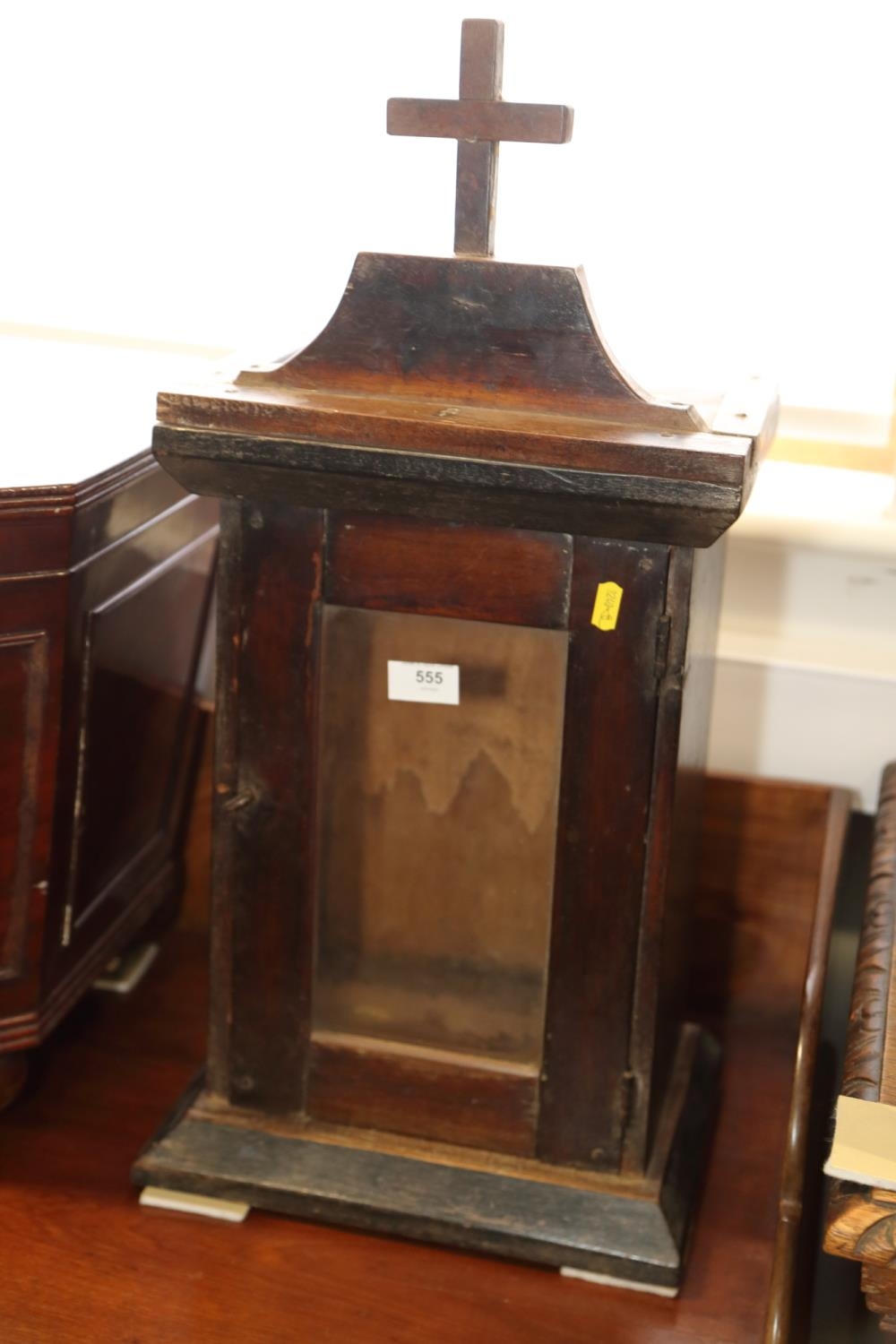 A 19th century Continental mahogany side cabinet with cross surmount, enclosed single glazed panel