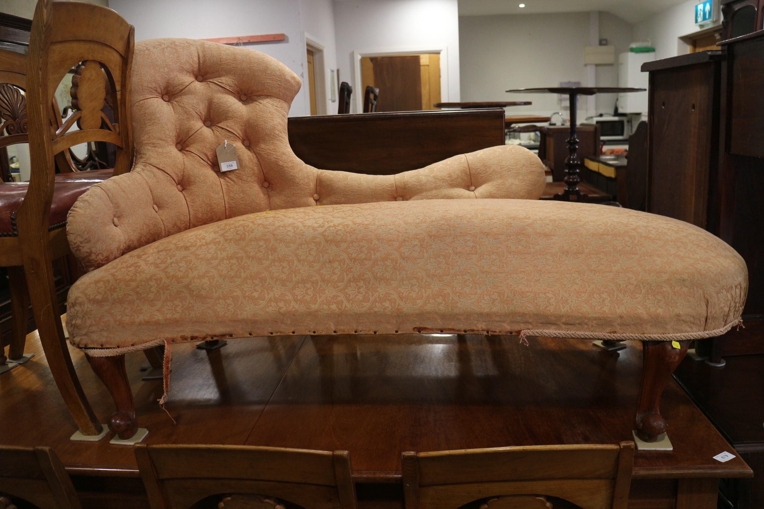 A late 19th century shaped back chaise longue, button upholstered in a peach brocade, on cabriole