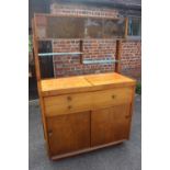 A 1950s figured walnut sideboard with glazed doors over shelves, three drawers and cupboards