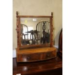 A 19th century mahogany bowfront toilet mirror, the plateau base fitted two drawers, on turned