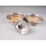 Two silver plated wine coasters and a similar wine funnel