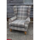 A contemporary wing armchair, upholstered in a grey tartan fabric, on square taper supports
