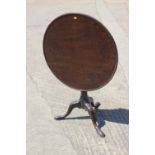 A George III mahogany single-piece circular tilt top table, with bird cage, on turned column and