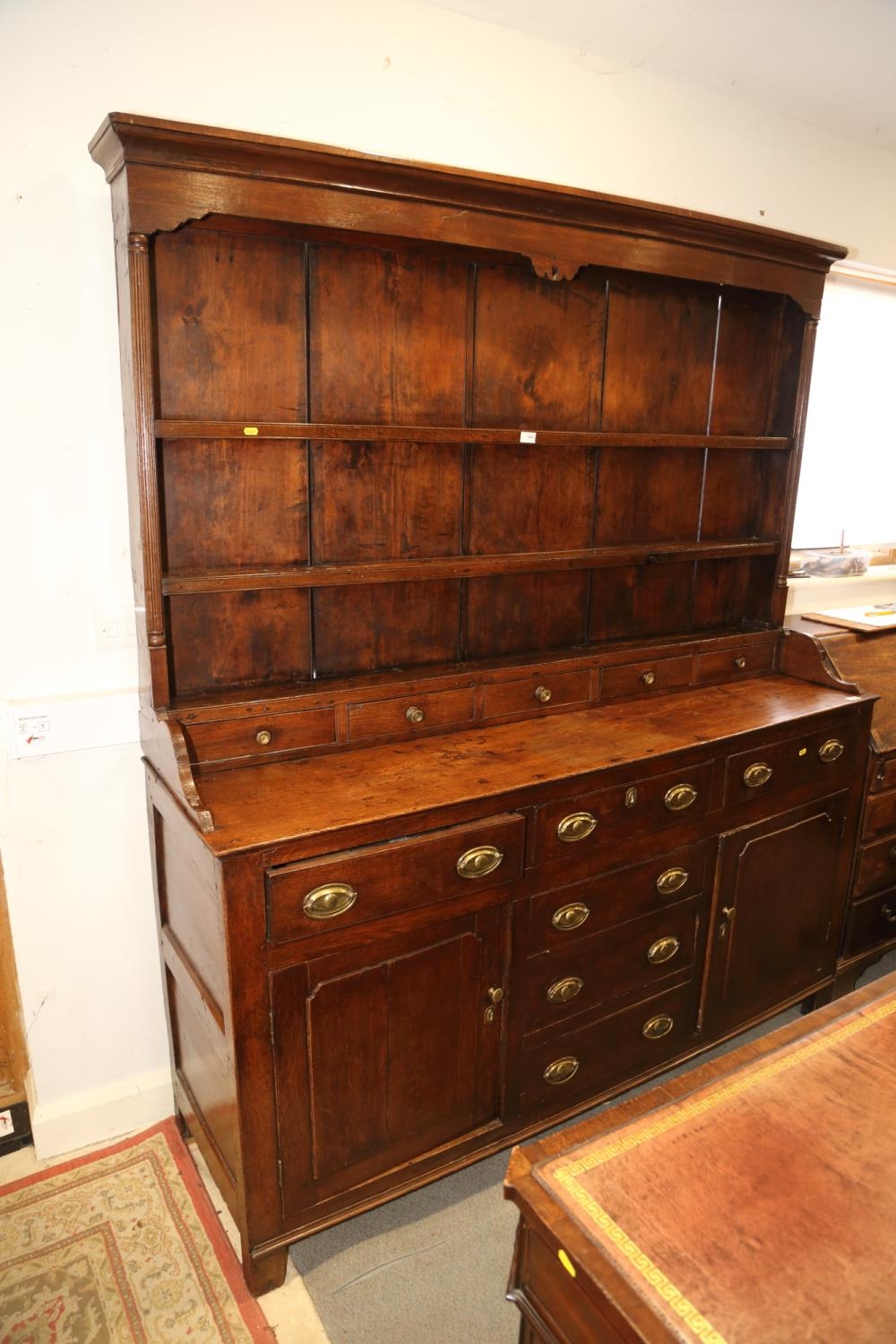 A 19th century oak dresser, the back fitted shelves over five small drawers with three further