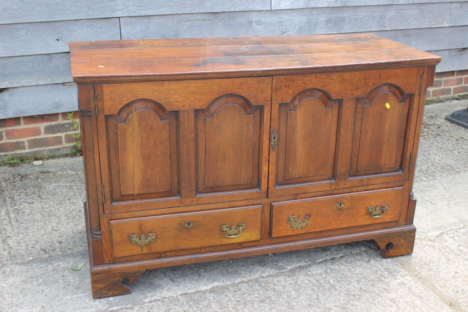 An 18th century oak mule chest, now converted as a cupboard, fitted two drawers, on bracket feet,