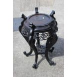An ebonised Chinese carved hardwood vase stand, on five shaped supports, 17" dia x 27" high