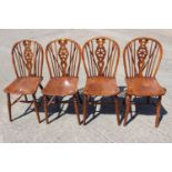 A set of four 19th century Windsor wheelback dining chairs with elm panel seats, on turned and