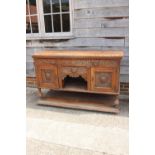 A carved oak sideboard of 17th century design, fitted two long drawers, over central small drawer