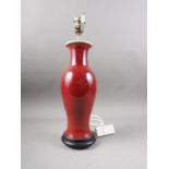 A Chinese sang de boeuf baluster table lamp, on turned hardwood stand, 17" high