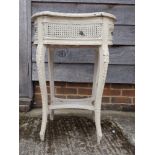 A white painted carved wood and rattan kidney shaped plant stand, 31" high