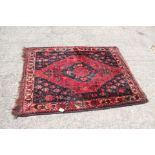 A Bokhara rug with central medallion on a black ground and multi-bordered in traditional colours,