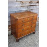 A bachelor's figured walnut and feather banded chest, fitted slide over four long graduated drawers,
