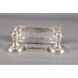 A pair of filled silver squat candlesticks, 3" high, a silver hinged box with embossed decoration, 3