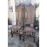 A pair of 19th century carved oak high back chairs, in the manner of Daniell Marot, on shaped