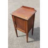 An Edwardian mahogany and satinwood banded bedside cabinet enclosed one door, on square taper