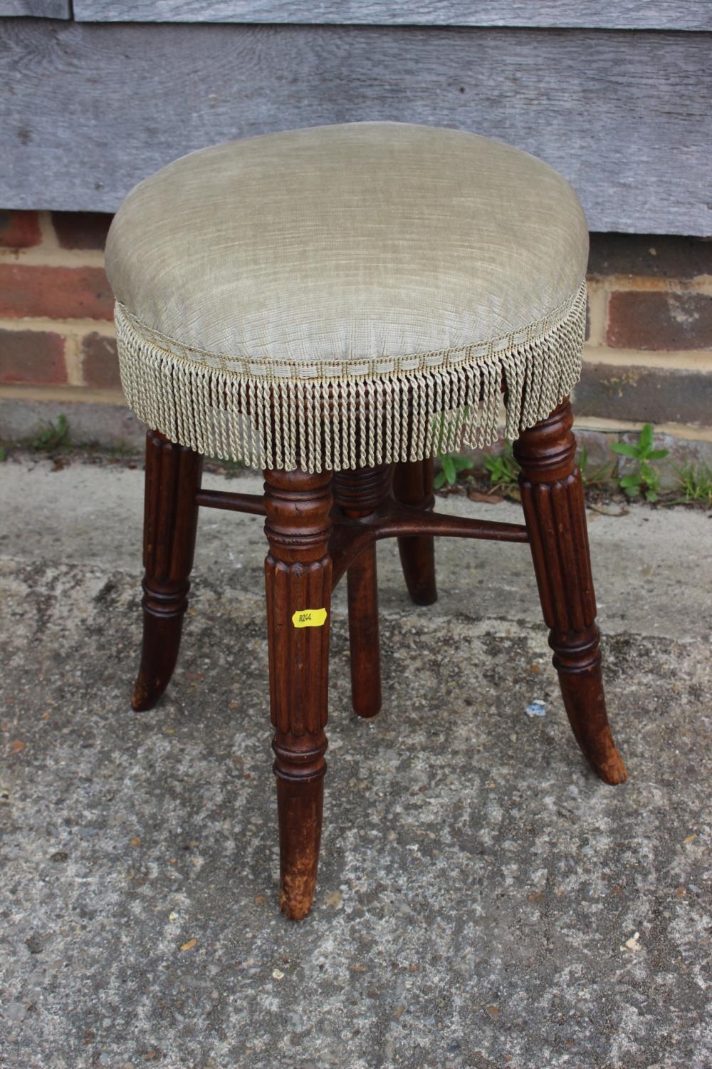 A mid 19th century mahogany piano stool with circular adjustable seat, on reeded stretchered