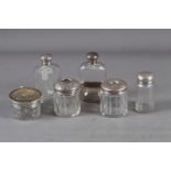 A silver topped hip flask with fitted silver cup, two silver topped hair tidy jars and three other