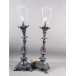 A pair of bronzed table lamps with scroll and flower design, on triform base, 22" high, together