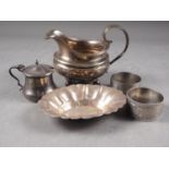 A silver milk jug (damages), two silver napkin rings, a silver mustard pot and a sterling silver