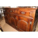 A Titchmarsh & Goodwin oak side cupboard of 17th century design, fitted three doors over cupboards