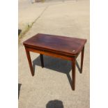 A 19th century mahogany box and ebony line inlaid fold-over top tea table, on square taper supports,