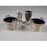 A pair of silver salt cellars, formed as coopered buckets with blue glass liners, a silver pepper