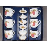 A boxed set of six Royal Worcester "Evesham" pattern chocolate cups and covers, and two glass